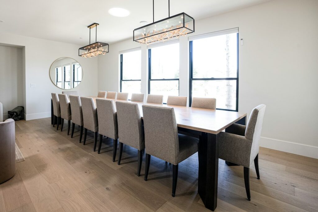 Bright dining room with a long solid wood table and upholstered chairs, showing the scale a live edge dining table needs
