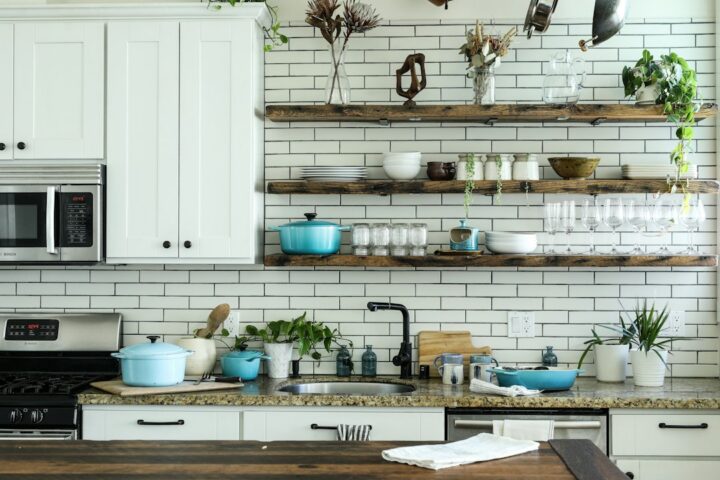 Live edge shelves in solid oak displaying crockery and plants on a kitchen wall