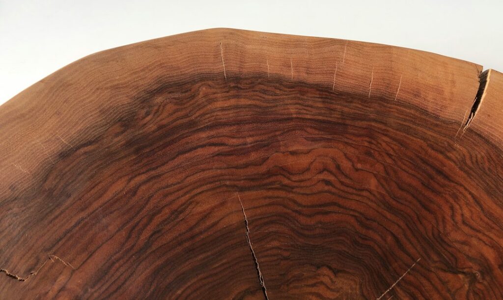 Natural wooden slab showing grain and edge character, the kind of live edge wood used for bespoke furniture