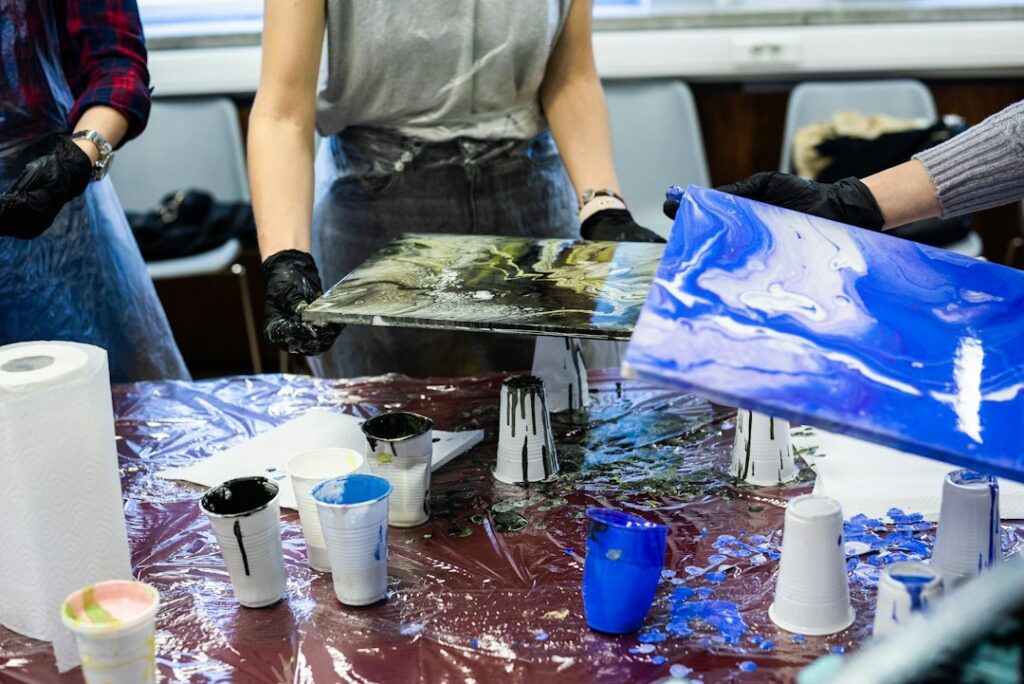 Cups of mixed coloured resin ready for an art pour, the kind of project a two part epoxy is used for
