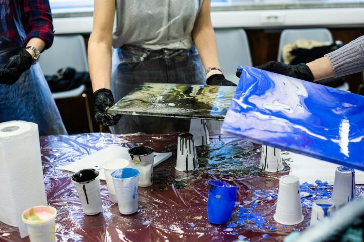 Cups of mixed coloured resin ready for an art pour, the kind of project a two part epoxy is used for