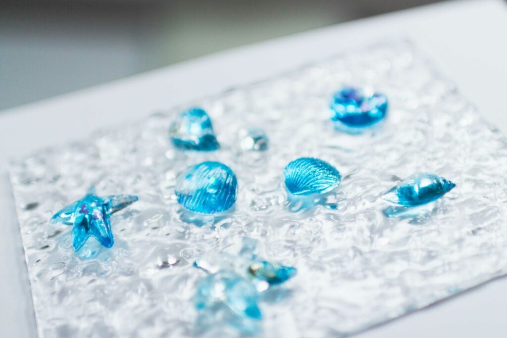 Seashell-shaped resin piece cast in a mould for resin casting, showing a clean glossy finish
