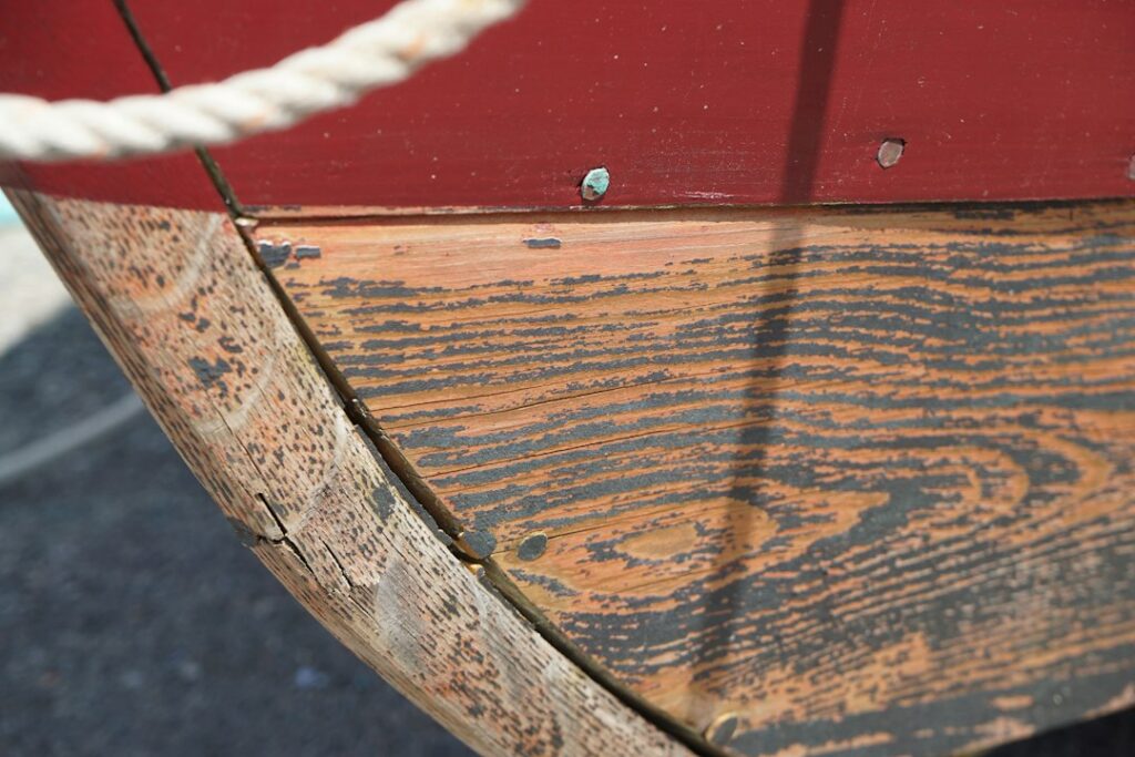 Marine epoxy being rolled onto a plywood boat hull during construction